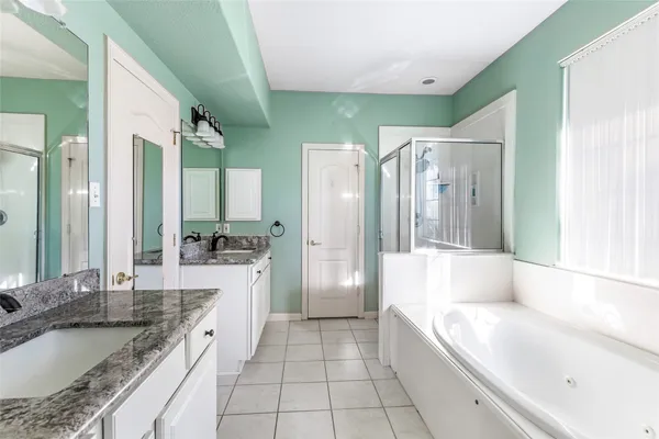 a large bathroom with a granite countertop tub sink and mirror