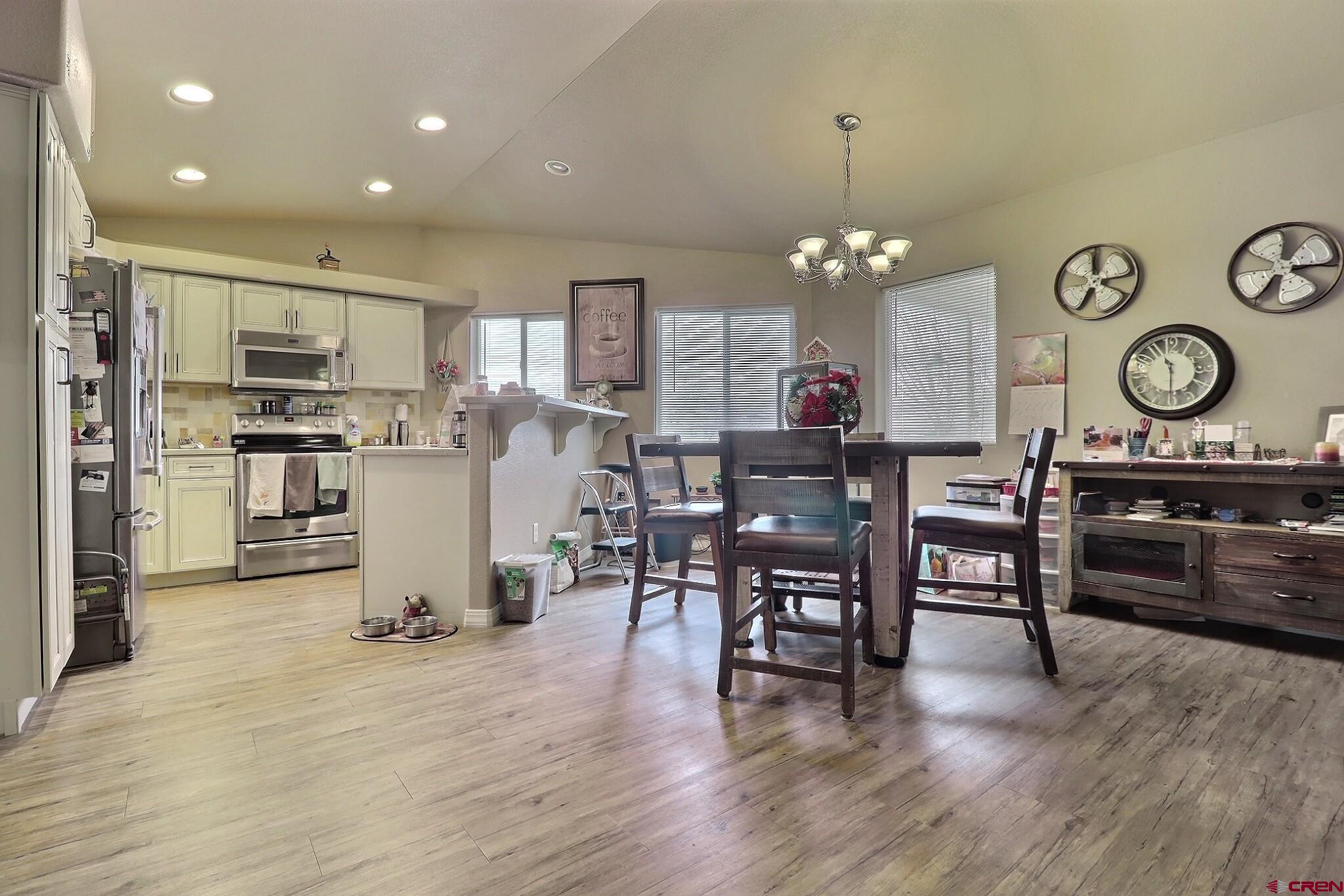 786 Dutton Street Delta, CO 81416 - Photo 9 of 29 the dining area located between the kitchen and the living room and family room. Note the ceiling area plant stands lining the oppostive wall