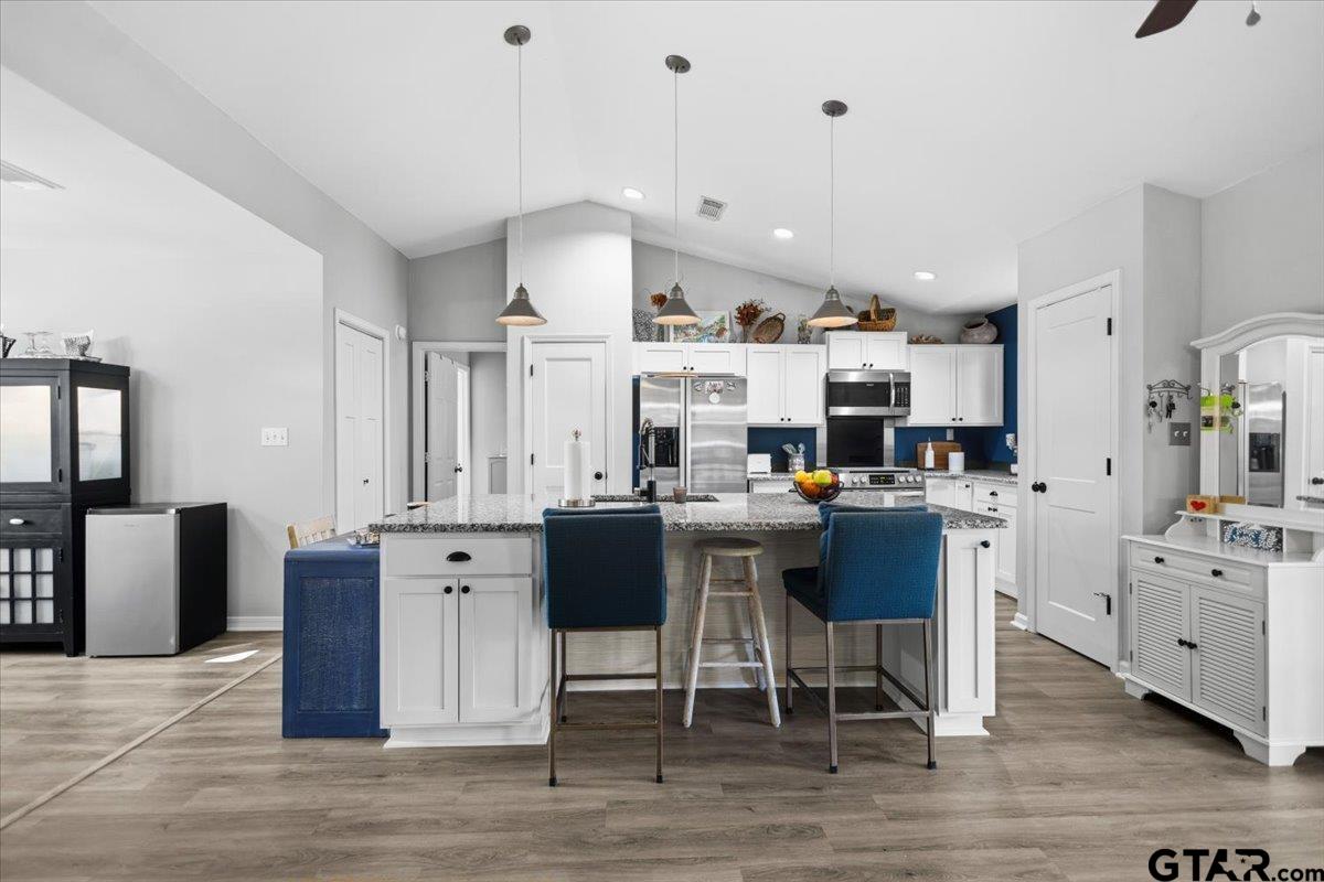 289 Acapulco Road Jefferson, TX 75657 - Photo 5 of 30 a kitchen with stainless steel appliances kitchen island granite countertop a table chairs and a refrigerator