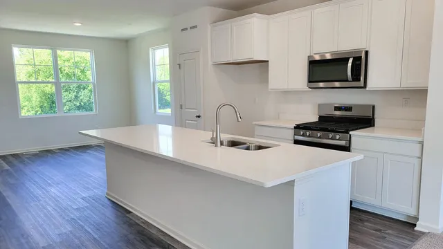 a kitchen with a sink a microwave and wooden floor