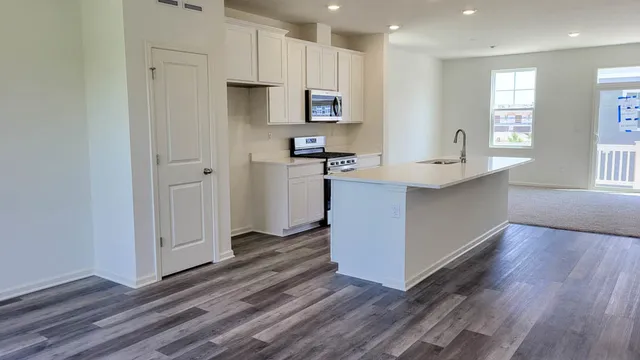 a kitchen with stainless steel appliances granite countertop a refrigerator and a stove top oven