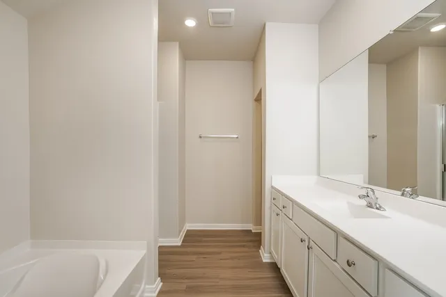 a bathroom with a double vanity sink and a bathtub
