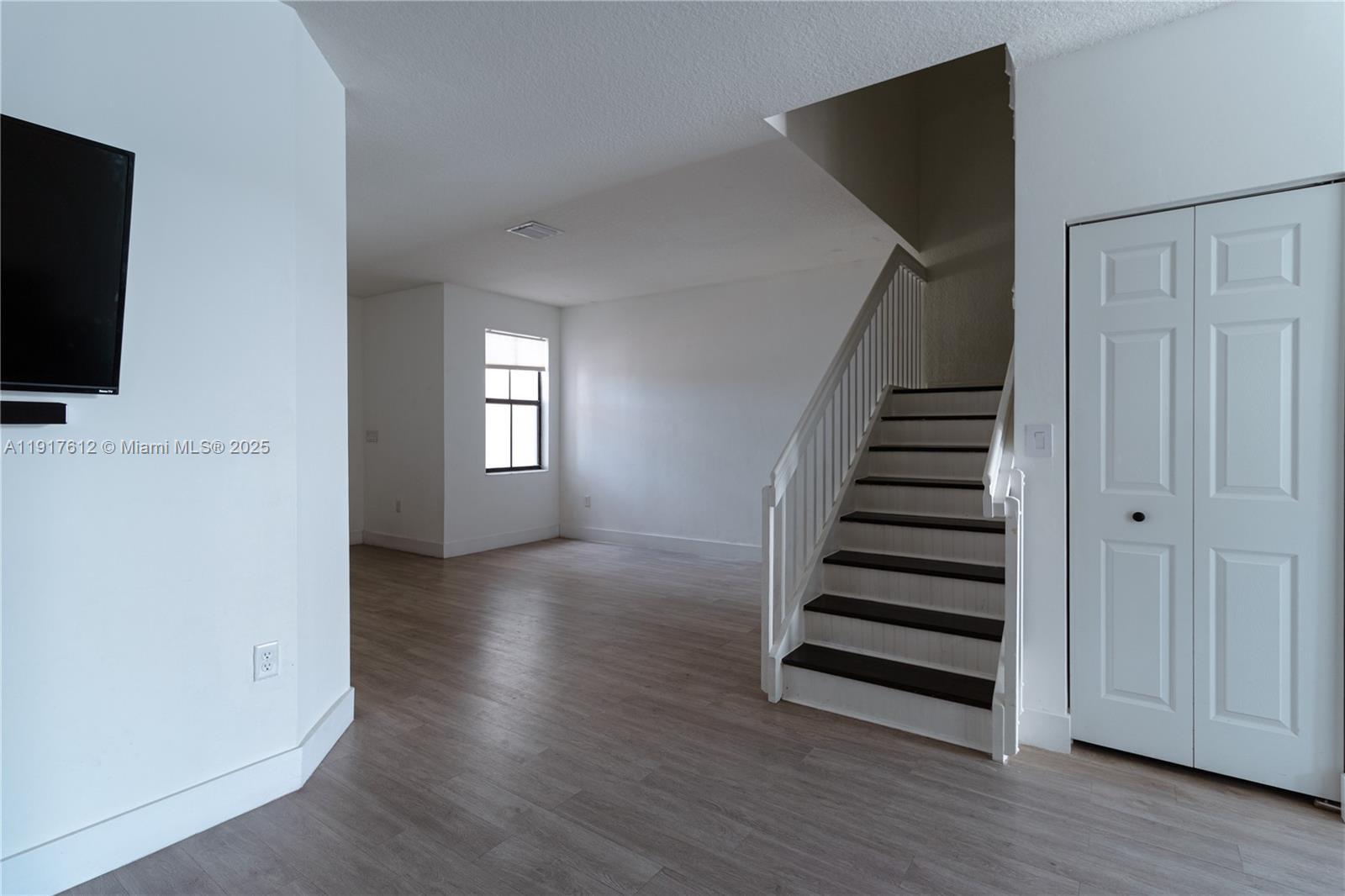 3435 West 105th Street Hialeah, FL 33018 - Photo 5 of 41 a view of a livingroom with wooden floor and white walls