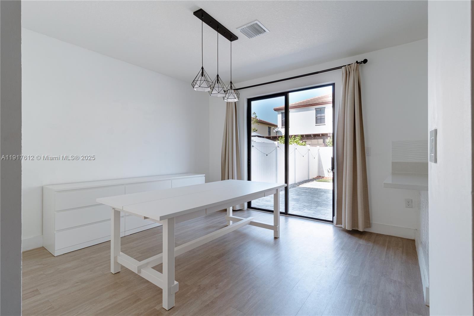 3435 West 105th Street Hialeah, FL 33018 - Photo 6 of 41 a room with wooden floor and windows