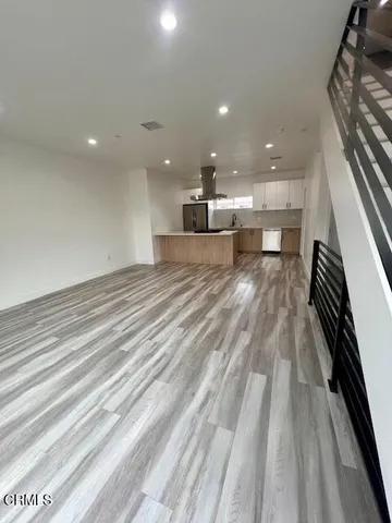 a kitchen with a sink and wooden floor