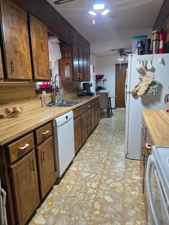 a kitchen with granite countertop a sink stove and cabinets