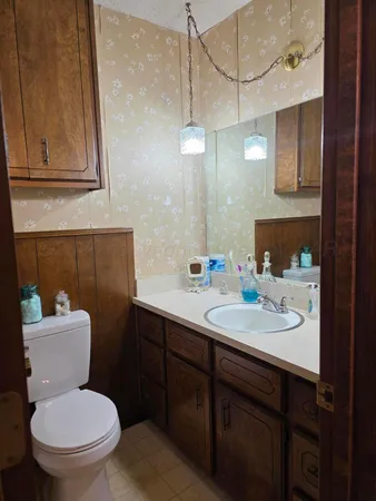 a bathroom with a toilet sink and mirror