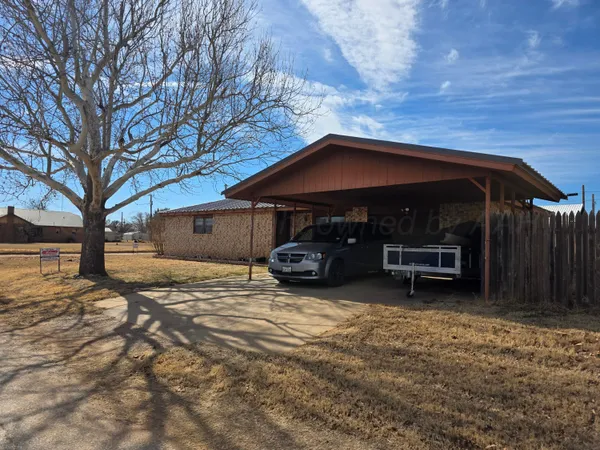 a view of a house with a yard and wooden fence