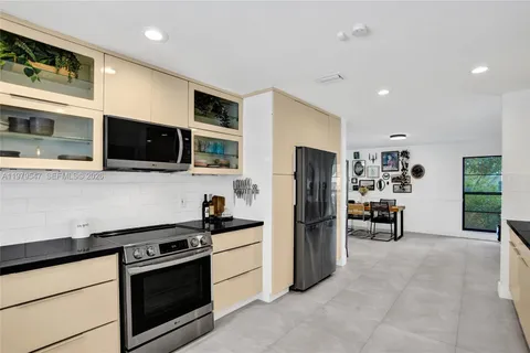 a kitchen with stainless steel appliances kitchen island granite countertop a refrigerator stove and microwave