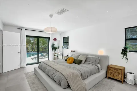 a bedroom with a large bed and a chandelier
