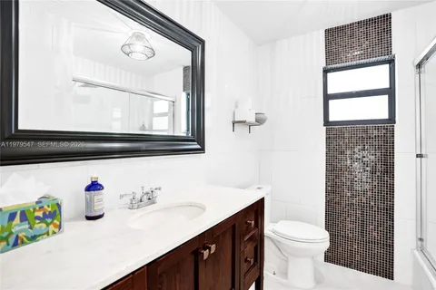 a bathroom with a sink vanity mirror and toilet