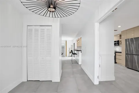 a view of a hallway with a dining table a chandelier