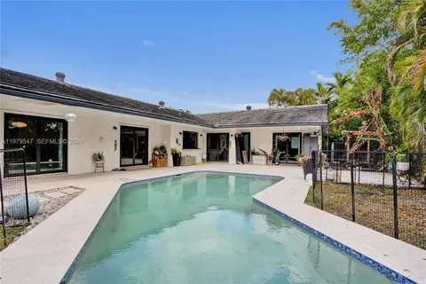 a view of a house with swimming pool and sitting area