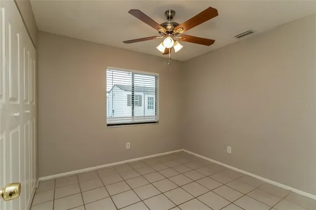 an empty room with windows and fan