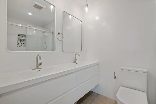 a bathroom with a sink a toilet and shower