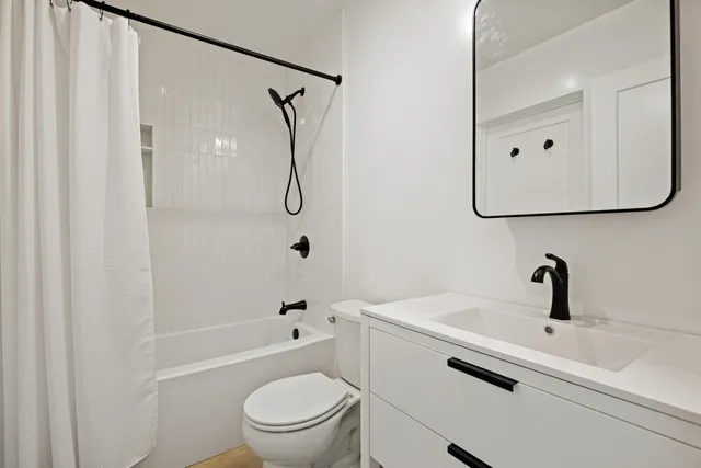a bathroom with a sink a toilet and a mirror