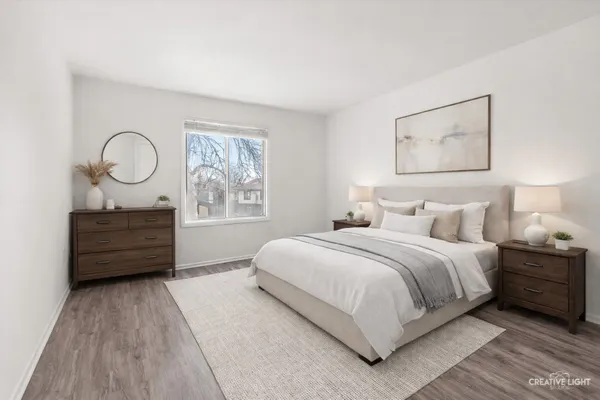 a spacious bedroom with a bed a mirror and a window