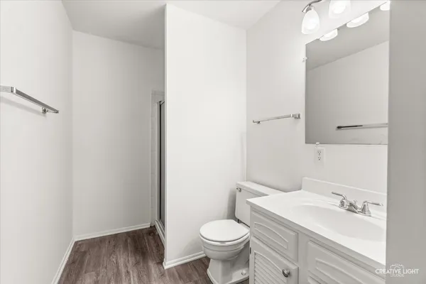 a bathroom with a granite countertop toilet sink and mirror