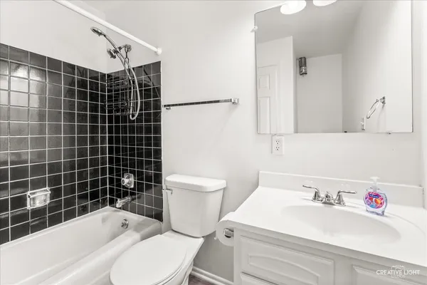 a bathroom with a sink toilet vanity and shower