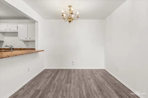 a view of a room with wooden floor and cabinets