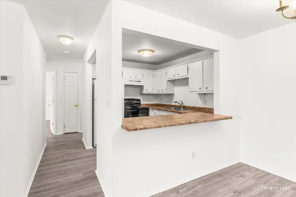 a kitchen with a refrigerator a sink and dishwasher with wooden floor
