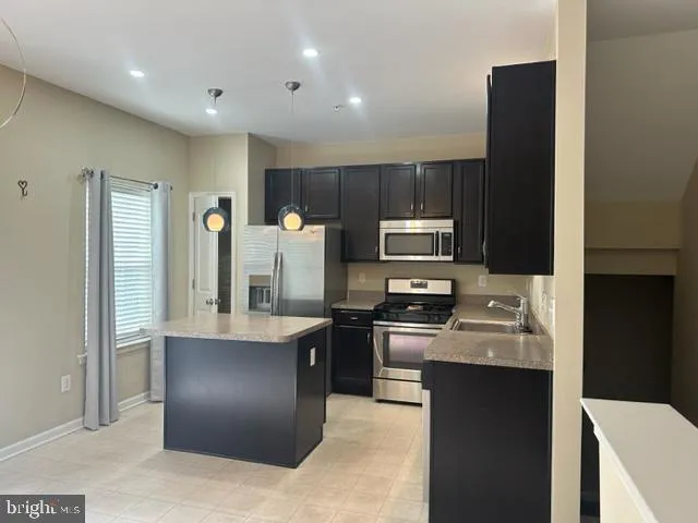 a kitchen with stainless steel appliances granite countertop a refrigerator and a stove top oven
