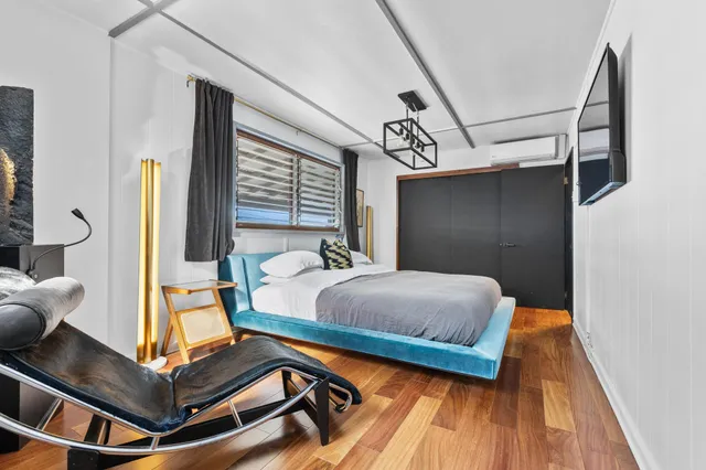 a bedroom with a bed and wooden floor