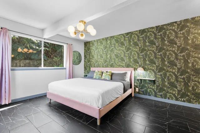 a bed sitting in a bedroom next to a window