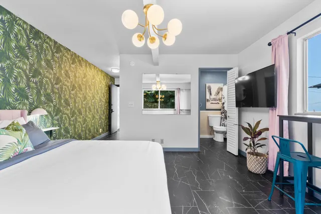 a bedroom with a bed and a flat tv screen on the dresser