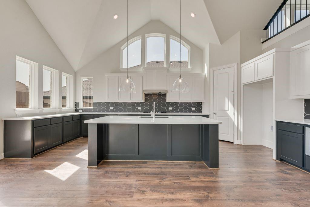 1231 Calebria Way Fate, TX 75087 - Photo 11 of 40 a kitchen with stainless steel appliances granite countertop a sink dishwasher a stove and a refrigerator