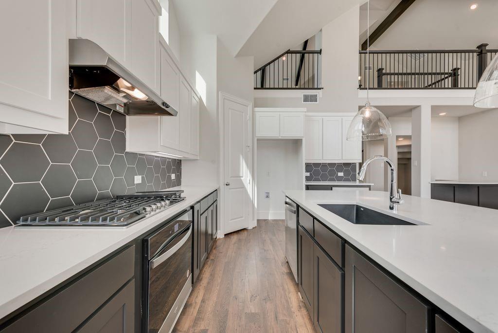 1231 Calebria Way Fate, TX 75087 - Photo 15 of 40 a kitchen with stainless steel appliances granite countertop a sink stove and cabinets