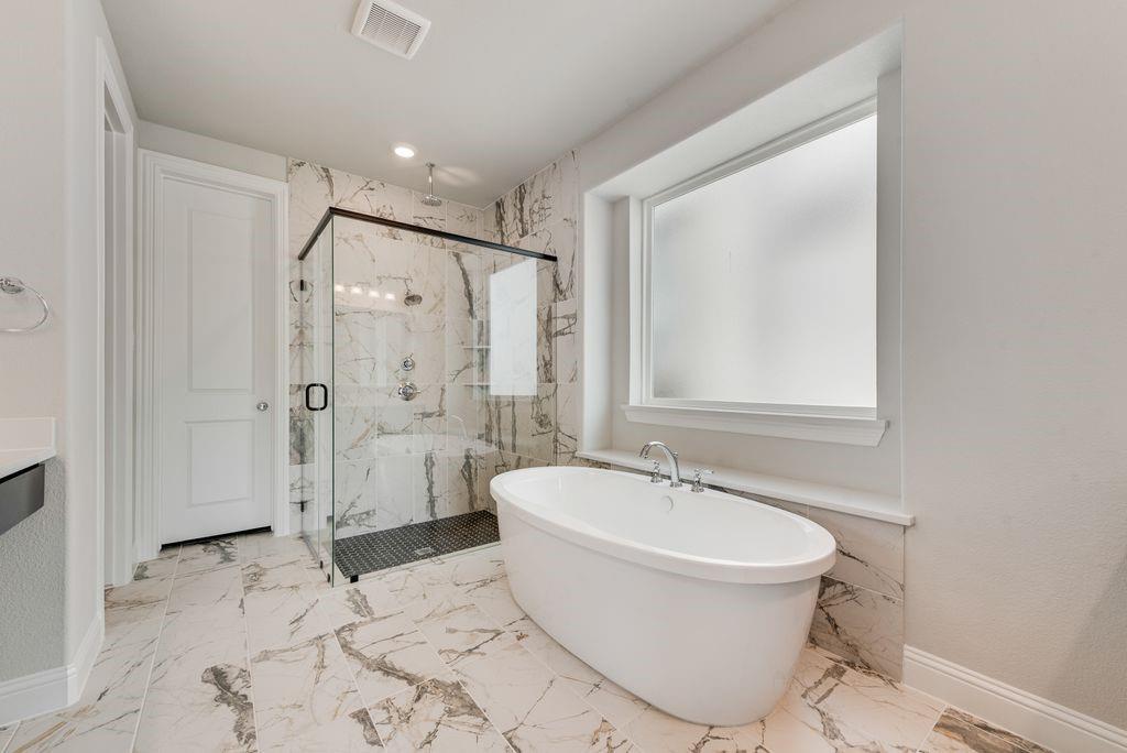 1231 Calebria Way Fate, TX 75087 - Photo 21 of 40 a bathroom with a bathtub shower sink mirror and toilet