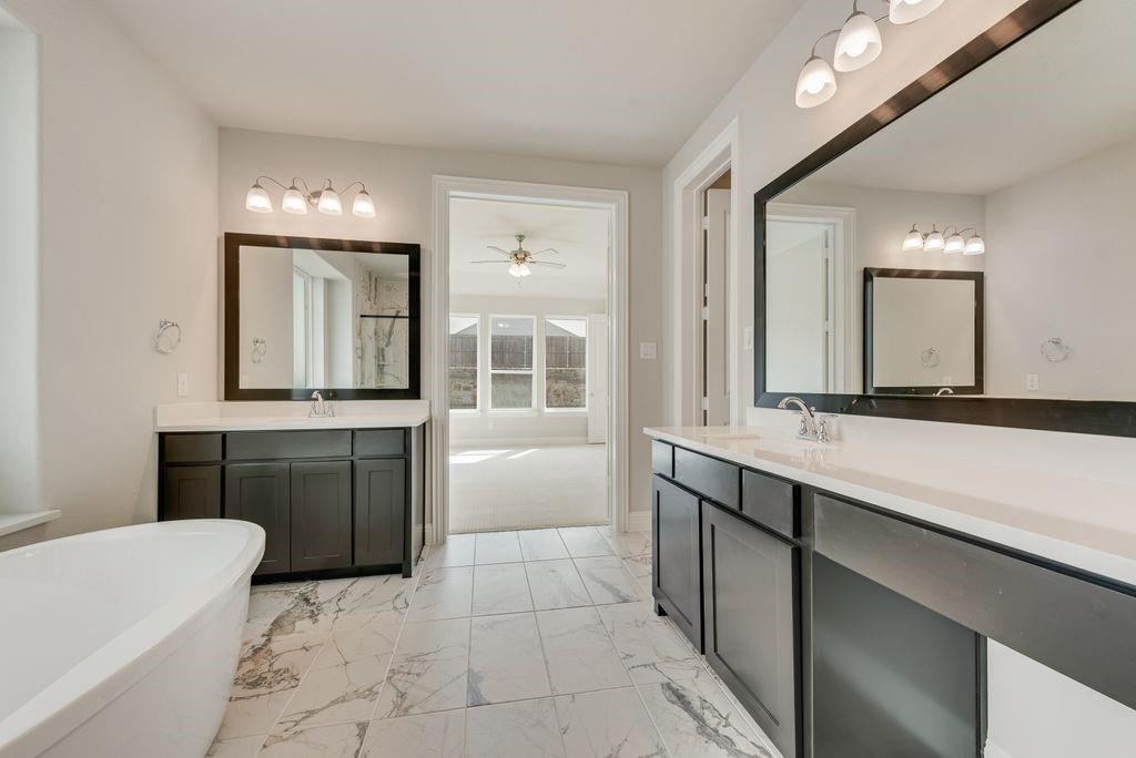 1231 Calebria Way Fate, TX 75087 - Photo 22 of 40 a bathroom with a tub sink and mirror
