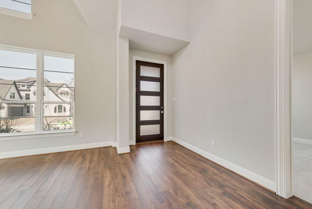 1231 Calebria Way Fate, TX 75087 - Photo 3 of 40 an empty room with wooden floor and windows