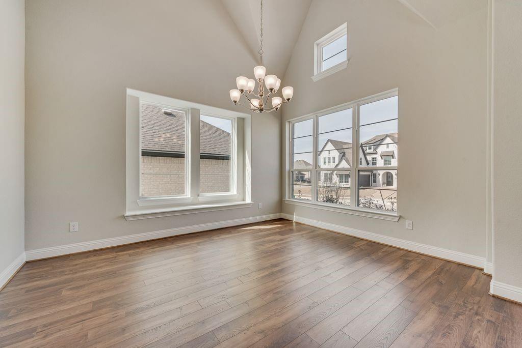 1231 Calebria Way Fate, TX 75087 - Photo 5 of 40 a view of an empty room with wooden floor and a window