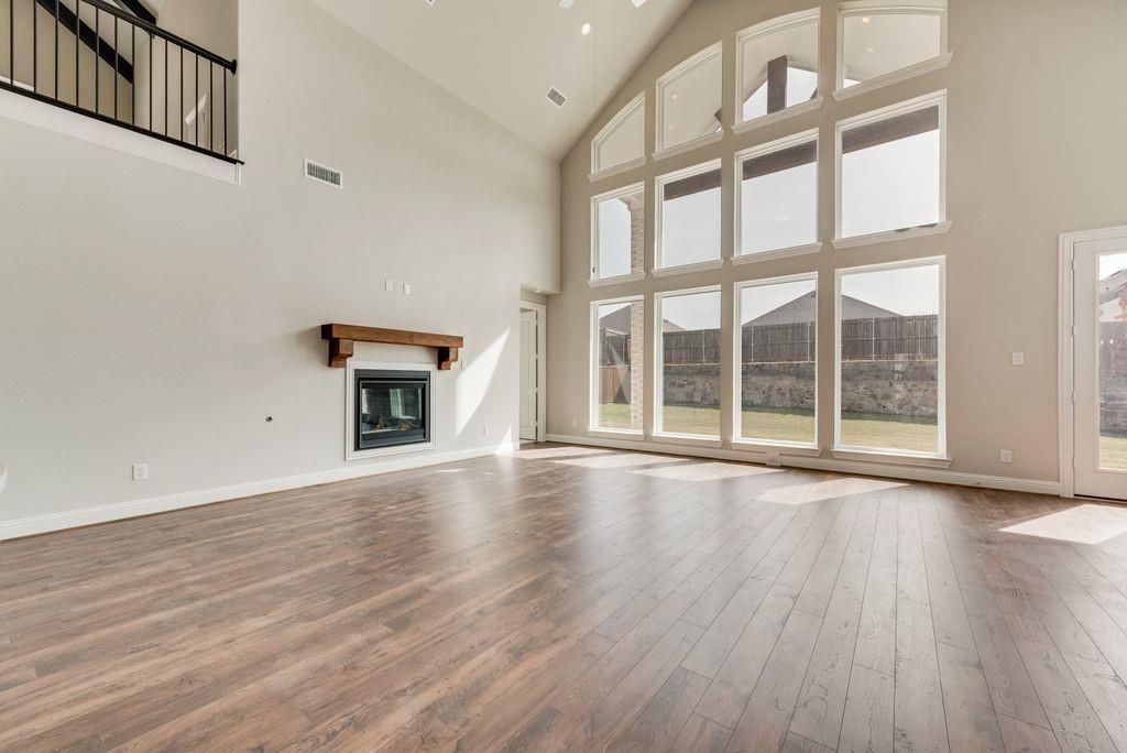 1231 Calebria Way Fate, TX 75087 - Photo 7 of 40 an empty room with wooden floor and windows