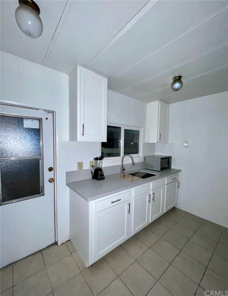 1782 Nisson Road, Unit 17 Tustin, CA 92780 - Photo 2 of 6 a kitchen with stainless steel appliances granite countertop a sink and white cabinets