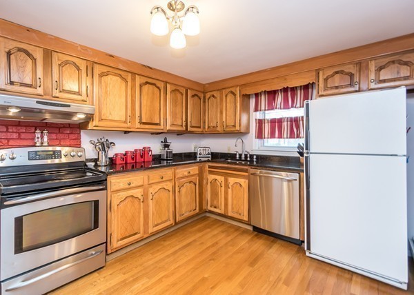 1131 Trapelo Road Waltham, MA 02451 - Photo 6 of 23 a kitchen with granite countertop cabinets stainless steel appliances and a wooden floor
