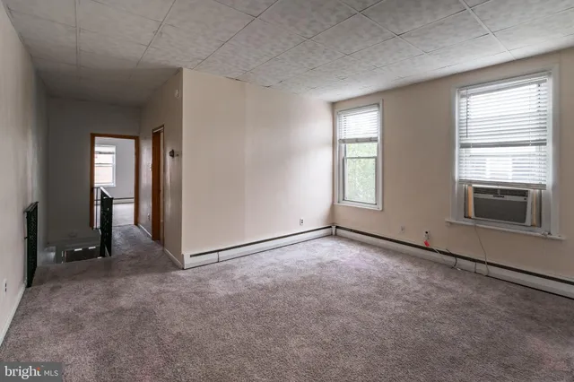an empty room with windows and closet