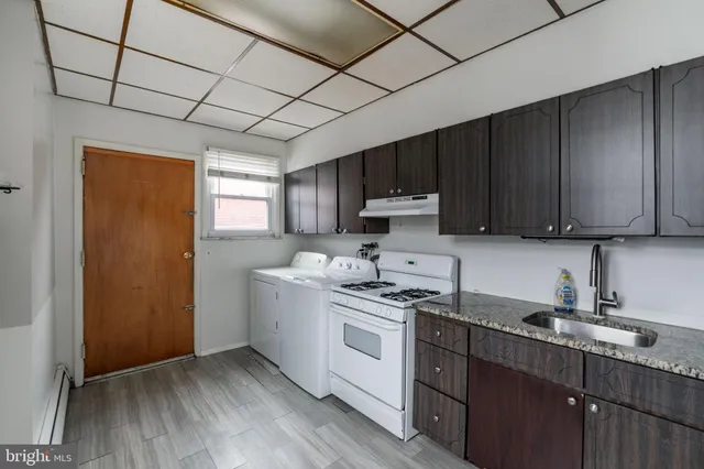 a kitchen with a sink a stove a refrigerator and cabinets