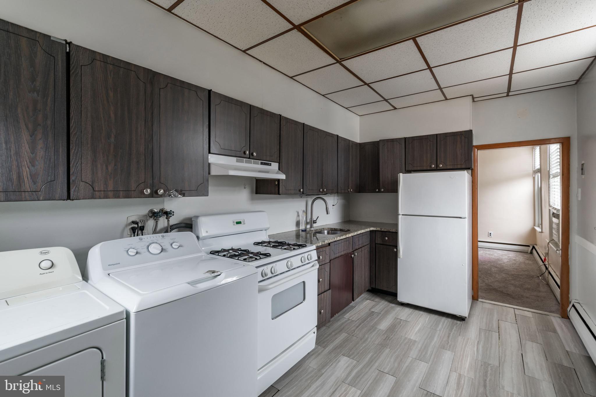 1325 West Porter Street Philadelphia, PA 19148 - Photo 7 of 17 a kitchen with a sink a stove a refrigerator and cabinets