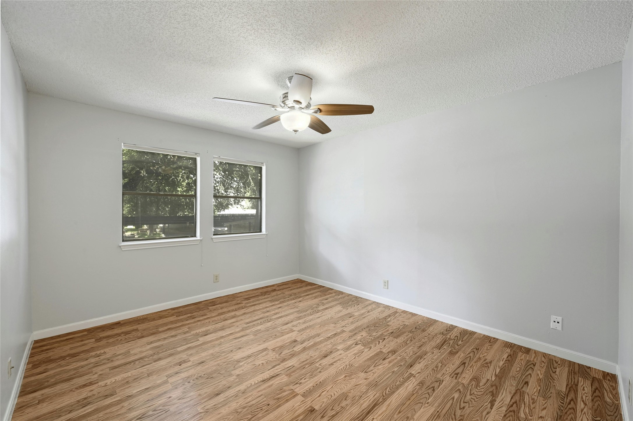 9226 Jollyville Road, Unit 221 Austin, TX 78759 - Photo 18 of 20 Rich hardwood-style flooring and overhead fan illuminate this spacious, versatile bedroom.