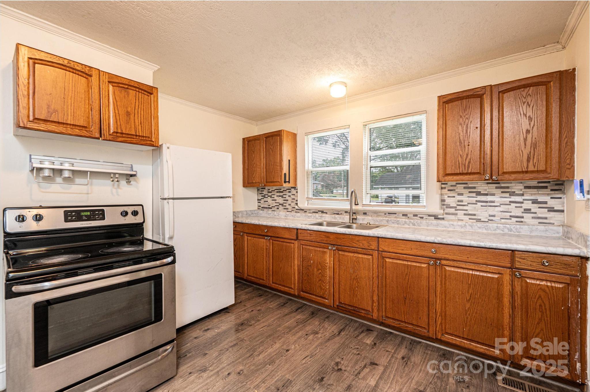 504 North Spring Avenue Newton, NC 28658 - Photo 20 of 35 a kitchen with granite countertop wooden cabinets stainless steel appliances and a window