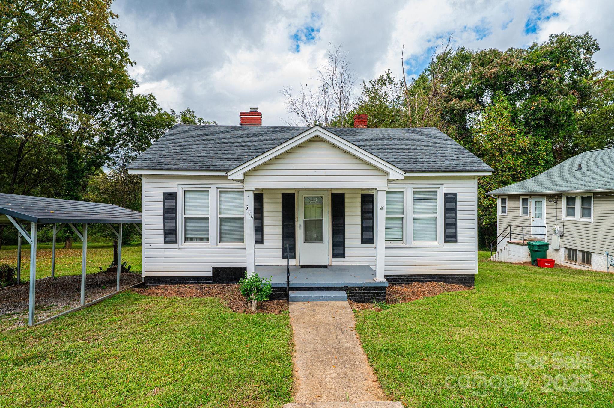 504 North Spring Avenue Newton, NC 28658 - Photo 4 of 35 a front view of a house with a yard table and chairs