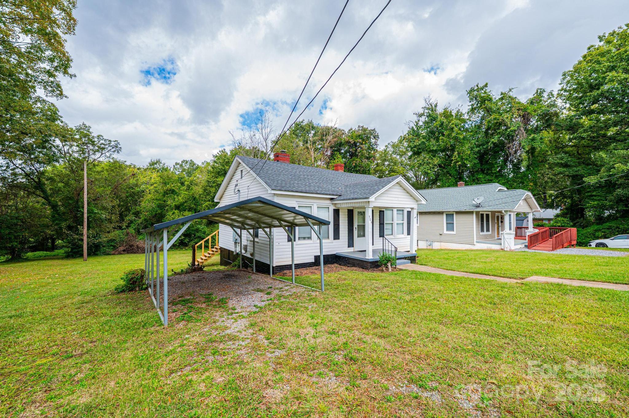 504 North Spring Avenue Newton, NC 28658 - Photo 6 of 35 a white house that has a big yard and plants