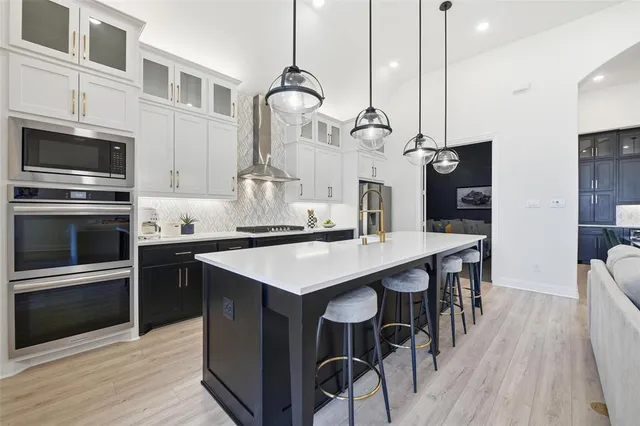 a kitchen with a sink a microwave a stove and chairs