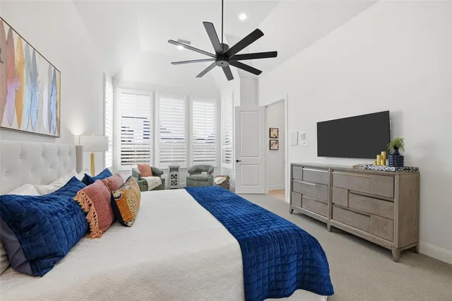 a bedroom with a bed window and a flat screen tv