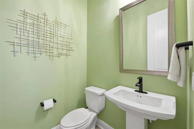 a bathroom with a sink a toilet and mirror