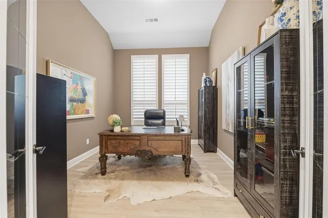 a view of a workspace with furniture and a window