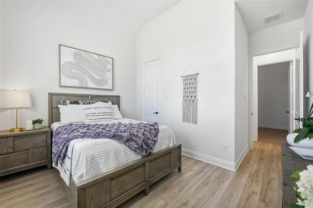 a bedroom with a bed and painting on the wall